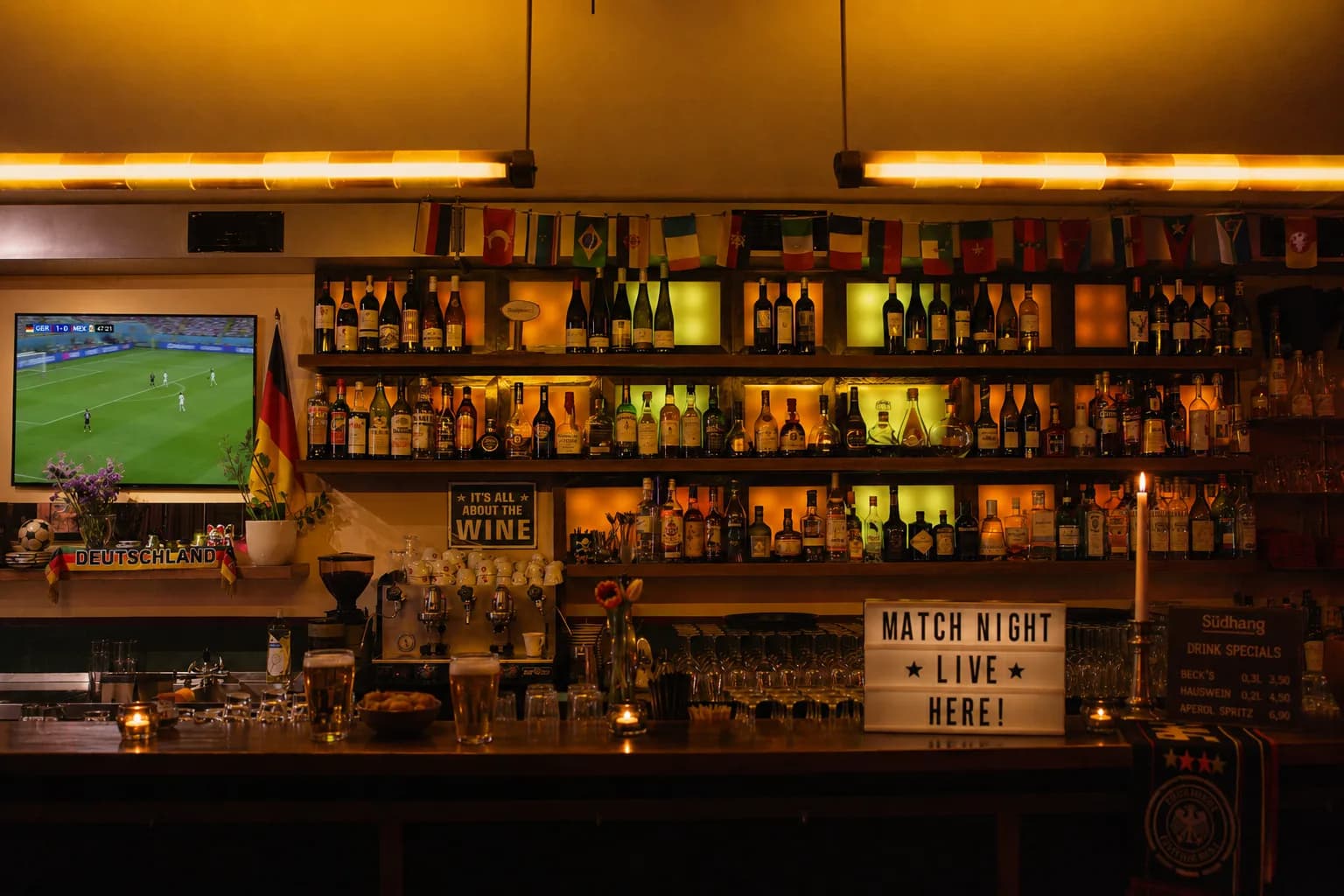 Südhang Weinbar in Hamburg mit Weinregal, Match-Night-Leuchtschild, Bar und Fußballscreen