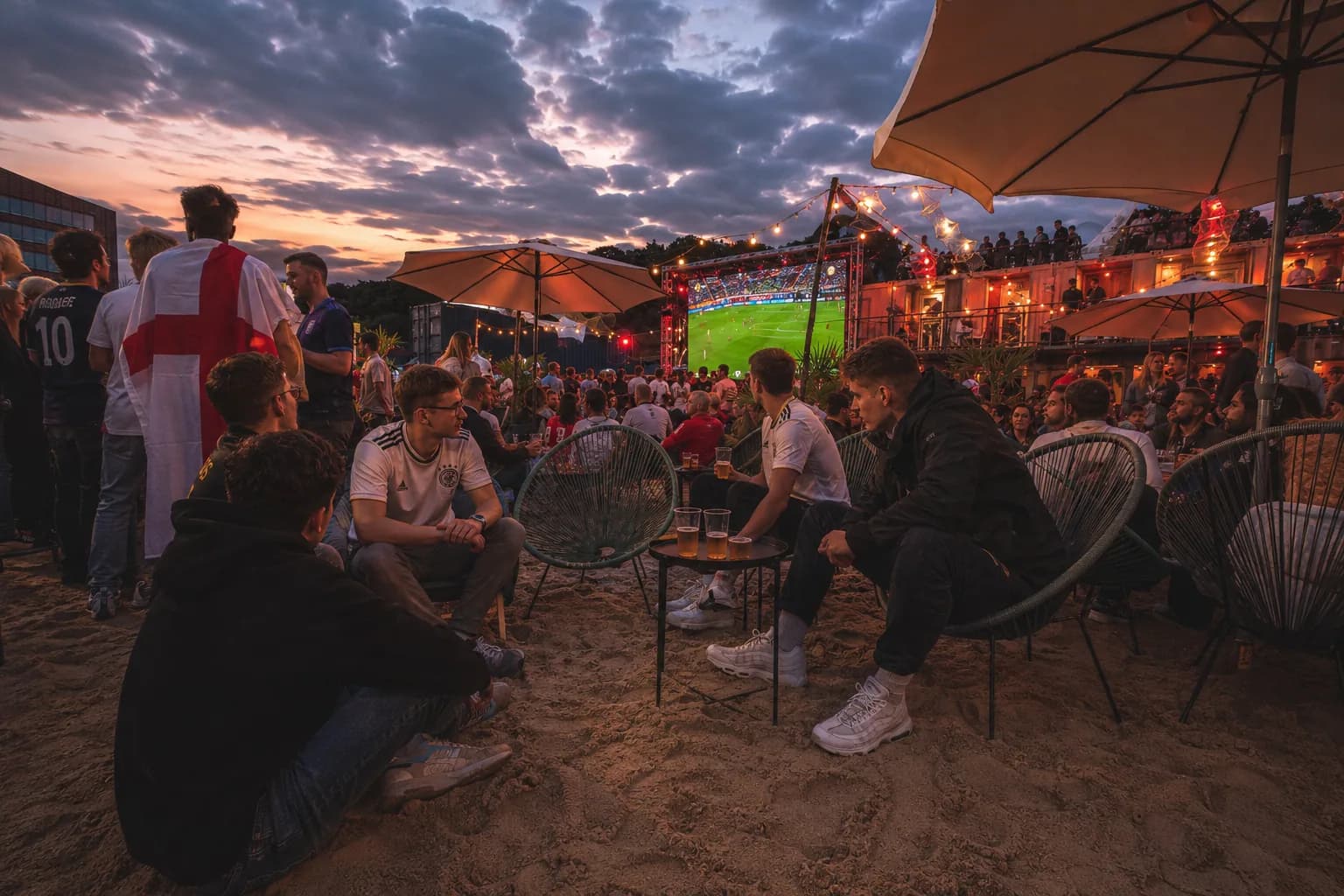 Lounge-Bereich beim Public Viewing Hamburg mit Sitzgruppen, Schirmen und Blick auf die Fußball-Leinwand